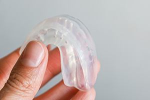 Closeup of patient holding clear mouthguard